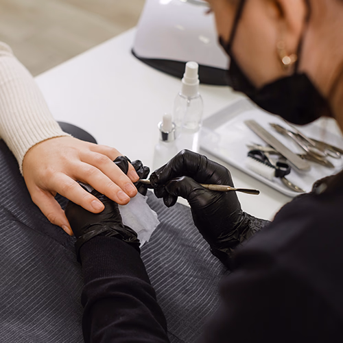 Professional nail technician giving a manicure to a client